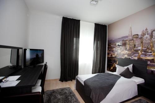 a hotel room with a bed and a television at Hotel Poarta Transilvaniei in Bistriţa