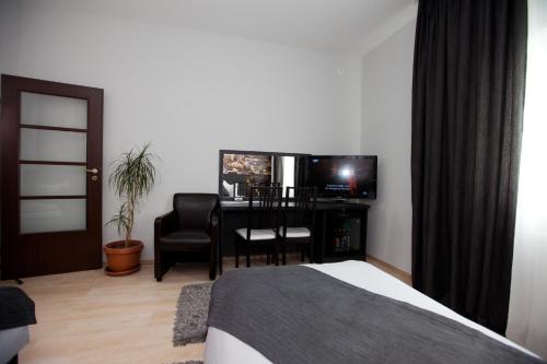 a bedroom with a bed and a desk with a television at Hotel Poarta Transilvaniei in Bistriţa