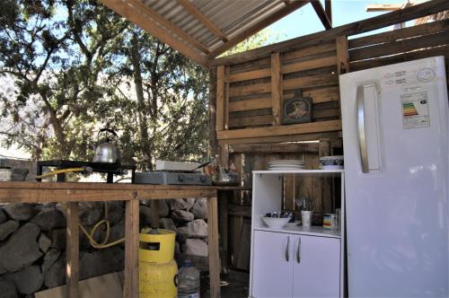 cocina con nevera blanca y encimera en Astro Camping Experience, en Vicuña