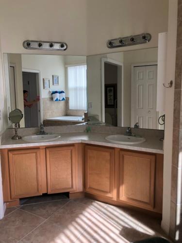 a bathroom with two sinks and a large mirror at Disney's Great Escape's Villa! 15 Minutes From Disney in Davenport