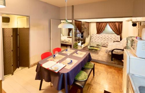 a kitchen and living room with a table and chairs at Holiday Homes TSUBOYA 202 in Naha