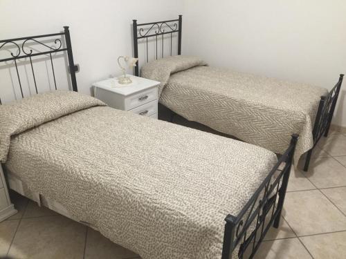 due letti uno accanto all'altro in una stanza di Domus Anna a Torre Annunziata