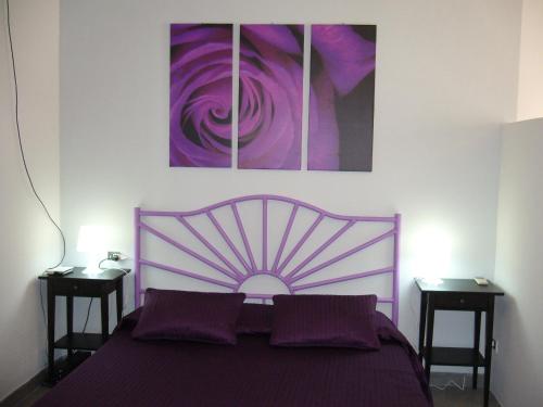 um quarto com uma cama roxa com duas mesas de cabeceira em Cuore Di Palme em Floridia