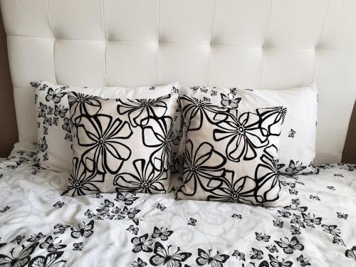 a black and white bed with two pillows on it at Kalina apartment in Ruse