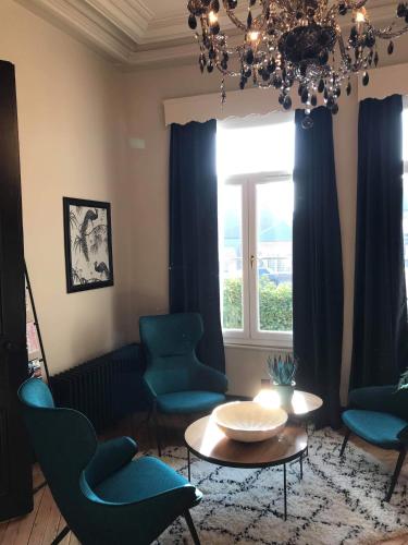 a living room with blue chairs and a table and a window at La villa 10 HÔTEL SPA in Étretat