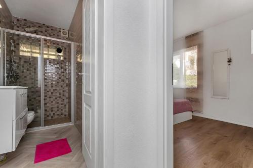 a bathroom with a shower and a pink rug at Apartment Rita in Makarska
