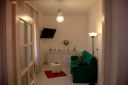 un salon avec un canapé vert et une télévision dans l'établissement Villa Panoramica, à Terracine