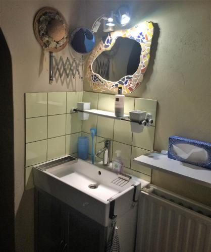 a bathroom with a sink and a mirror on the wall at Bed and Garden Alde Coninckshof in Weurt