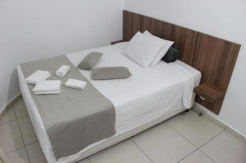 a large bed with white sheets and pillows on it at Pousada Caminho Dos Escravos in Diamantina