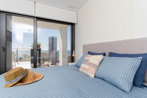 a bedroom with a bed with a hat on it at Urbano Blanco Apartments in Calpe
