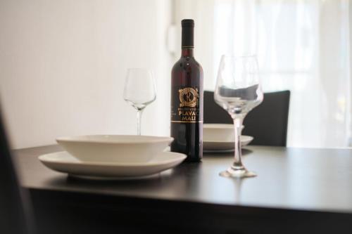 a bottle of wine and two glasses on a table at Apartment Nicol in Zadar