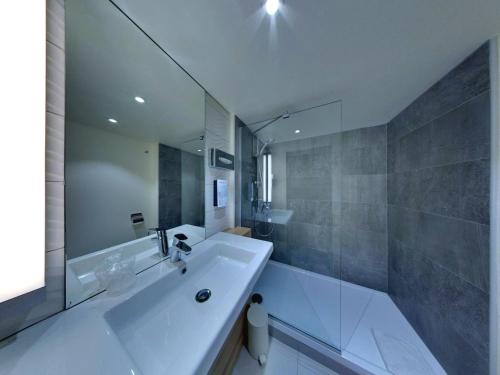 a bathroom with a large white tub and a sink at Campanile Orléans Centre Gare in Orléans