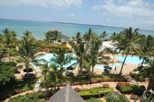a beach with palm trees and palm trees at Fruit & Spice Wellness Resort Zanzibar in Kizimkazi