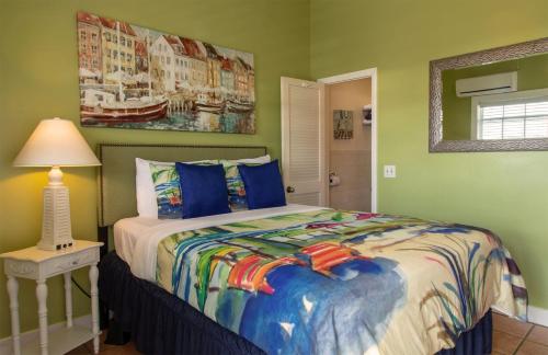 a bedroom with a bed and a table with a lamp at Caribbean House, No Resort Fees in Key West