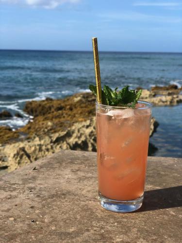a drink sitting on a ledge near the ocean at The Waves at Cane Bay in Kingshill