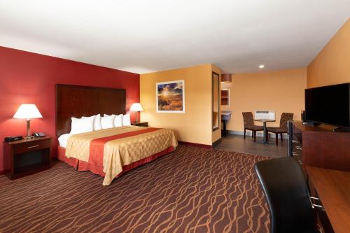 a hotel room with a bed and a flat screen tv at Days Inn by Wyndham Roseburg in Roseburg