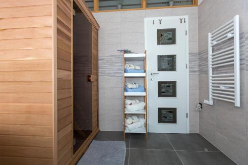 a bathroom with a door and a shelf with towels at Sensitive relax apartment in Rijeka