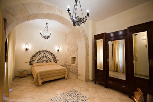una camera con letto e lampadario a braccio di Le Antiche Mura a Lecce