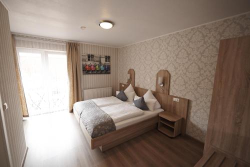 a bedroom with a bed and a window at Hotel Wurster Kroog in Bremerhaven