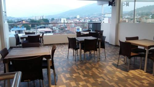un restaurante con mesas y sillas y una gran ventana en Hotel Girón Plaza, en Girón