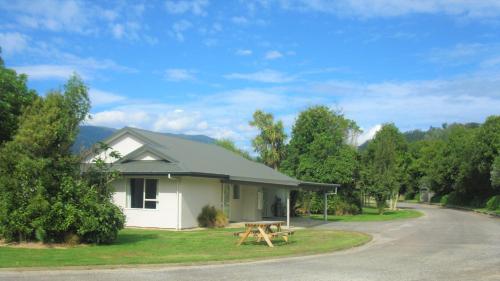 a picnic table in front of a house at Karamea River Motels in Karamea