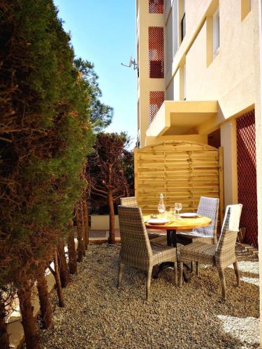 un patio avec une table et des chaises dans une cour dans l'établissement Grand studio 35m2 centre ville, à LʼÎle-Rousse