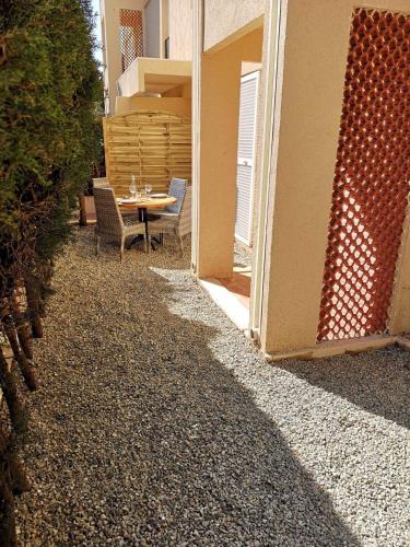 un patio avec une table et des chaises à côté d'un bâtiment dans l'établissement Grand studio 35m2 centre ville, à LʼÎle-Rousse
