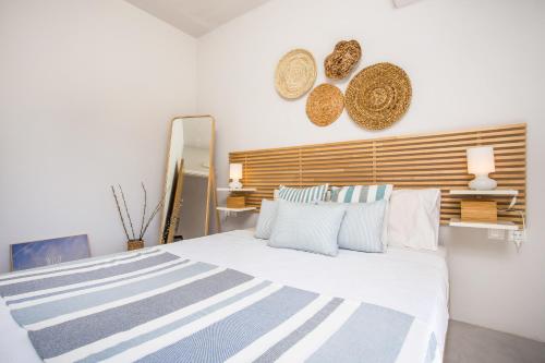 a bedroom with a large white bed with a wooden headboard at Euphoria Luxury apartment in Faliraki