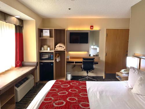 a hotel room with a bed and a desk at Microtel Inn & Suites by Wyndham Charleston in Charleston