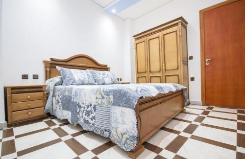 Schlafzimmer mit einem Bett und einer Holztür in der Unterkunft Résidence chaounia d'hote in Chefchaouen