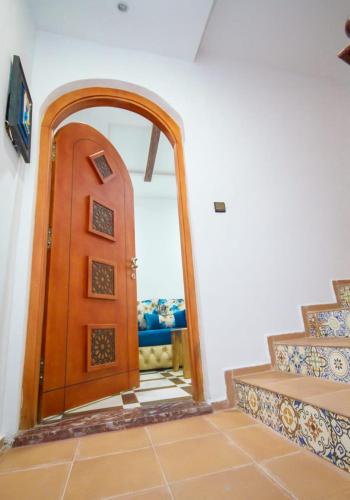 a wooden door in a room with a mirror at Résidence chaounia d'hote in Chefchaouene