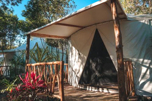 a tent with a bench in a yard at Huaya Camp in Tulum