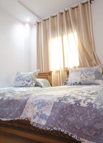 a bedroom with a bed with pillows and a window at Résidence chaounia d'hote in Chefchaouene