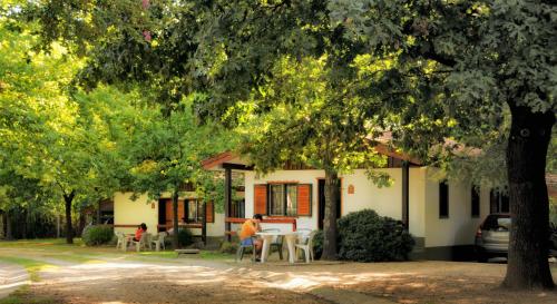 a woman sitting at a table in front of a house at Cabañas Alpendorf in Villa General Belgrano