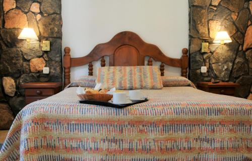 a bed with a bowl of fruit on a tray at Cabañas Alpendorf in Villa General Belgrano