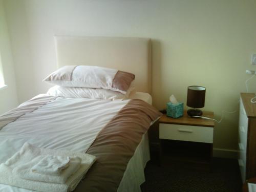 a bedroom with a bed with pillows and a night stand at Arlingtons in Blackpool