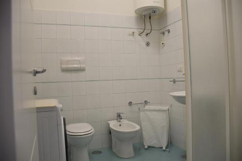 bagno bianco con servizi igienici e lavandino di casa Pepi a Olbia