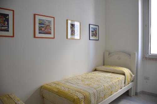 una camera con letto e quadri appesi al muro di casa Pepi a Olbia