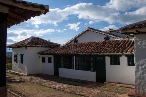 a white house with a red tile roof at Posada Campestre La Casona in Villa de Leyva