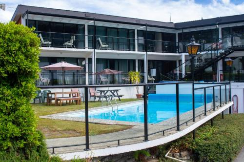 a hotel with a swimming pool in front of a building at Four Seasons Motel in Queenstown