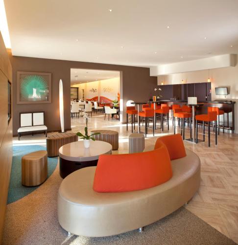 a living room with a couch and a dining room at Logis Hotel Restaurant Muller in Niederbronn-les-Bains