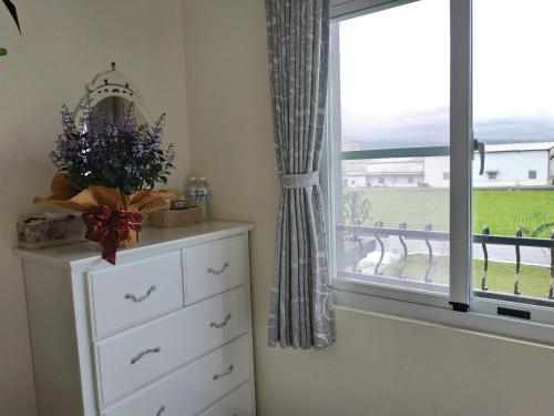 a dresser and a window with a view of a field at Ode to Mansions B&B in Chishang