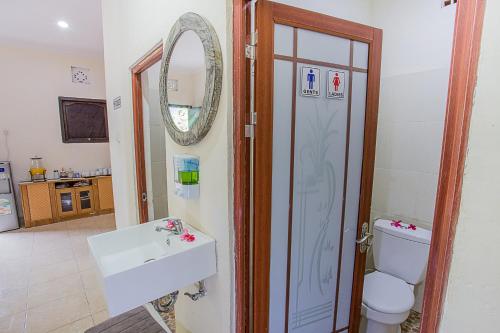Un baño con lavabo, inodoro y espejo. en Horizon Nusa Penida, en Nusa Penida