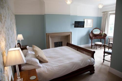 a bedroom with a bed with white sheets and a fireplace at Amberley Inn in Stroud