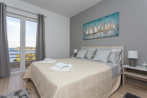 a bedroom with a bed and a large window at Apartments Maximus in Dubrovnik