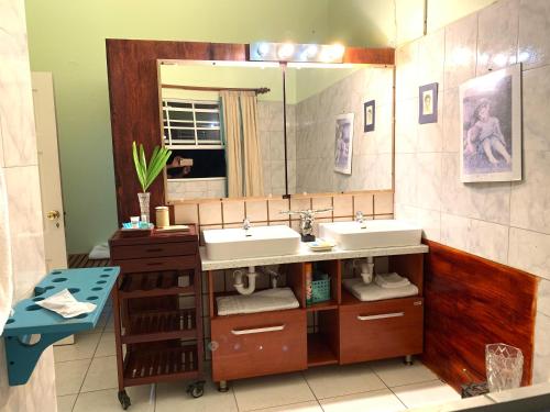 a bathroom with two sinks and a mirror at RNM The Clubhouse, Grenada in Mount Nesbit