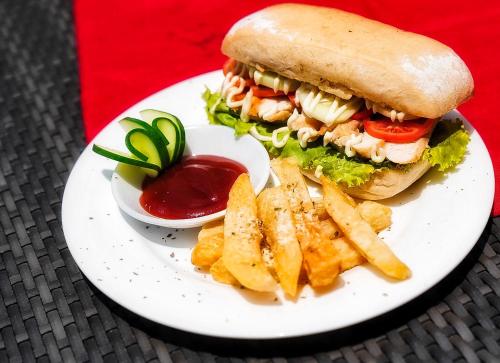 a sandwich and french fries on a plate with ketchup at Nacpan Beach Glamping Managed by H Hospitality Group in El Nido