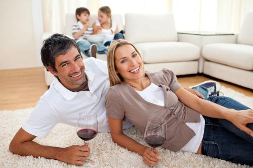 a man and woman sitting on the floor with wine glasses at Olympus Apartments in Quito
