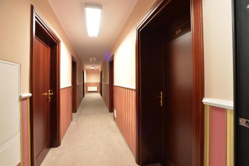a corridor of a hospital with wooden doors at Hotel Cesarski - Kaiserhof in Giżycko