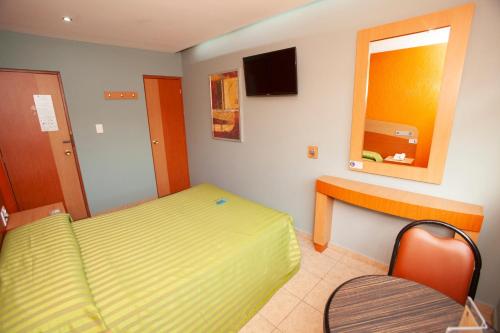 a small room with a bed and a mirror at Hotel Lira - Sólo Adultos in Mexico City